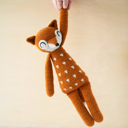 Crocheted orange amigurumi fox with white dots