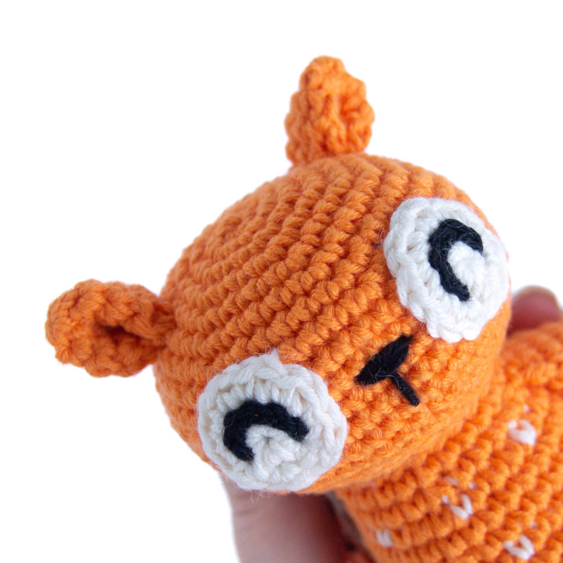 Close up of a crocheted orange happy squirrel face